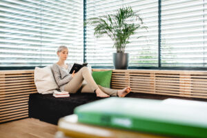 (c)Loxone_Sands-of-time_woman-reading-lounge-remote_04
